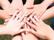 Hands in a circle on top of each other, community