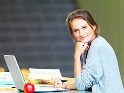 Woman studying in a library on laptop