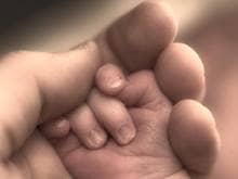 A hand holding a baby's hand