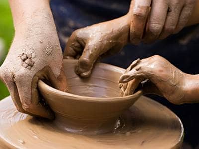 Two sets of hands on potters wheel