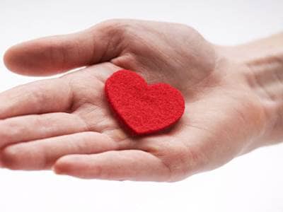 Hand holding a heart shaped trinket