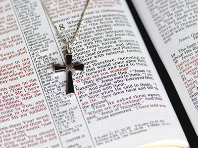 Cross necklace on the pages of an open Bible
