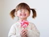 Little girl holding pink lollipop
