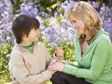 Son handing a flower bouquet to his mother