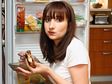 Woman Eating in Front of Refrigerator