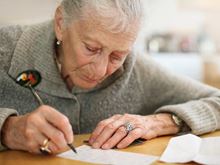 An elderly woman writing