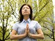 Asian woman meditating in the wood