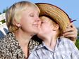 Grandson kissing grandmother on the cheek