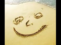 Smiley happy face drawn on beach sand