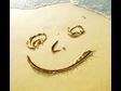 Smiley happy face drawn on beach sand