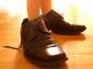 Little boy wearing his father's shoes