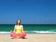 Woman meditating on beach