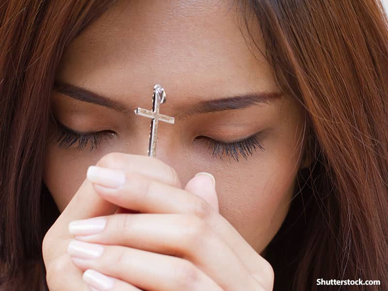 girl praying cross
