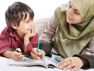 Muslim mother teaching son from coloring book