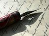 Old-fashioned pen against a letter
