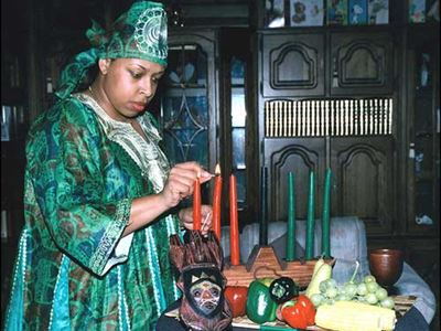 Woman lighting Kwanzaa kinara