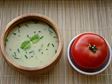 Simple bowl of soup broth and a tomato