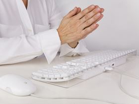 Praying Hands Over a Computer a Keyboard