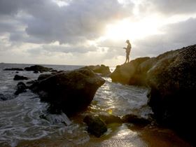Man fishing near the ocean