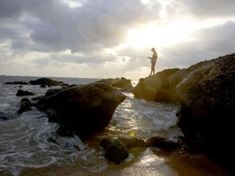 Man fishing near the ocean