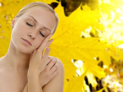 Blonde woman set against yellow leaf