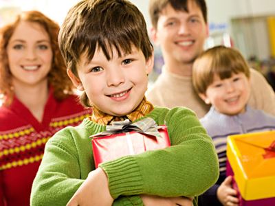 Boy hugging present, happy family
