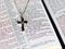 Cross necklace on the pages of an open Bible