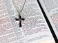 Cross necklace on the pages of an open Bible