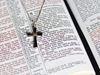 Cross necklace on the pages of an open Bible