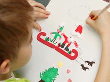 Child drawing Santa and an elf on a sleigh