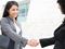Young women shaking hands