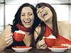 Girlfriends laughing over coffee
