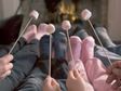 Family roasting marshmallows by the fireplace