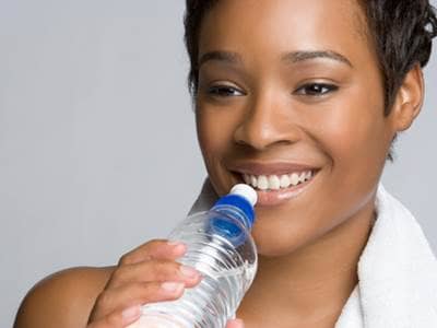 Exercising woman drinking water