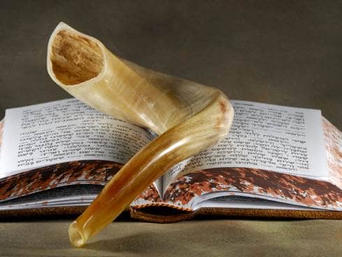 A shofar resting upon a hebrew book