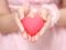 Little girl in a pink dress holding a pink heart