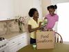 Mother and daughter filling food donation box