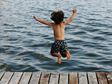 Boy Jumping into water from dock