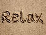 Relax written in sand