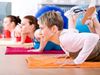 Three women practicing yoga in a gym with multi-colored yoga mats.