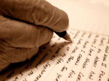 An elderly hand correcting a letter with a pen