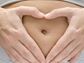 Pregnant belly with hands shaped in a heart